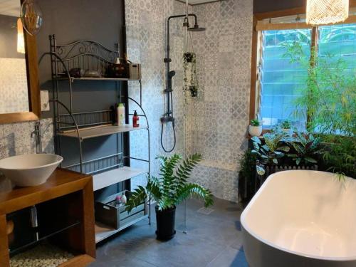 y baño con bañera y lavamanos. en Grande Maison Créole typique, en Les Avirons