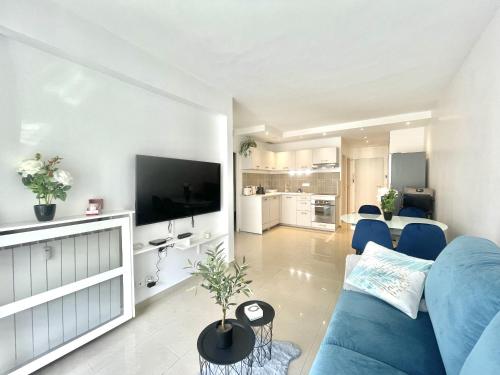 un salon avec un canapé bleu et une télévision dans l'établissement Colony 2, à Cannes
