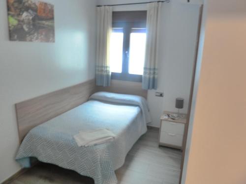 a small bedroom with a bed and a window at Hostal Casa Fermina- A 2 horas de las pistas de esquí in Trevélez