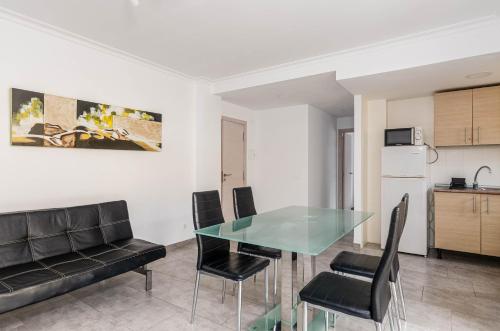 a dining room with a glass table and chairs at Acapulco Apartments in Can Picafort