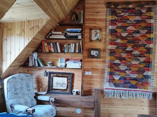 a room with a chair and a quilt on the wall at Big family Apartment in Breb's Cosy Barn in Breb