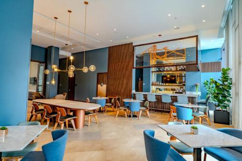 a restaurant with tables and chairs and a bar at Courtyard by Marriott Santiago Airport in Santiago