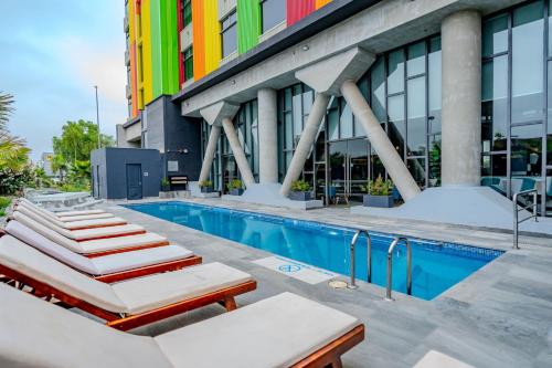 une piscine en face d'un bâtiment coloré dans l'établissement Courtyard by Marriott Santiago Airport, à Santiago