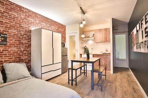a room with a kitchen and a table with chairs at Big Apple - Studio paisible - parking gratuit - 2 personnes - Village Vaux 3 minutes Auxerre in Auxerre