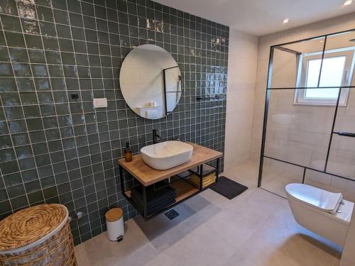 bagno con lavandino, specchio e doccia di Lucia's Residence a Mlini