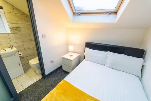 een kleine slaapkamer met een bed en een badkamer bij Spacious Comfortable studio near the university in Birmingham