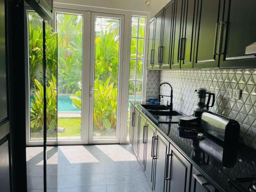 Roshe-Sky Guest House Colombo في Mahabage: مطبخ فيه مغسلة ونافذة