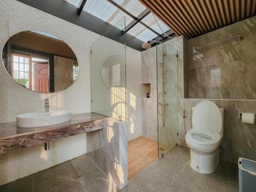 uma casa de banho com um WC, um lavatório e um espelho. em Dome The Heavenrest em Ban Khlong Ta Sang