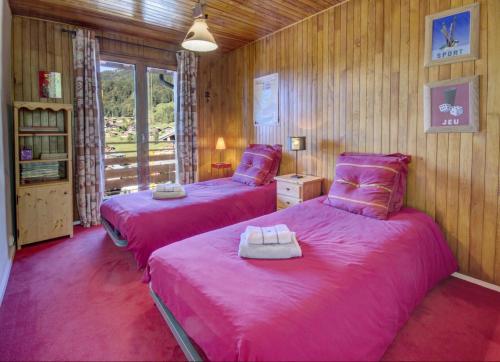 deux lits dans une chambre avec des draps roses dans l'établissement Résidence Le Val D'or - Appartement Val d'Or - 4 Personnes - Les Gets MAE-4061, aux Gets