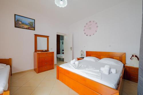 a bedroom with a bed and a clock on the wall at Vila Limos in Ksamil