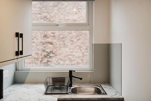 a kitchen with a sink and a window at Garmoyle Road Flat 2 in Liverpool