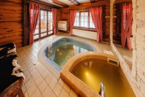 a bathroom with a jacuzzi tub in a cabin at Korunka in Tatariv