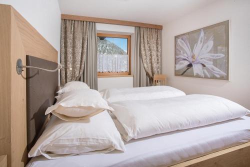 1 Schlafzimmer mit 2 weißen Betten und einem Fenster in der Unterkunft Romantik Ferienwohnungen in Pertisau