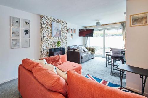 a living room with an orange couch and a television at Host & Stay - Shaftsbury in Burton Joyce