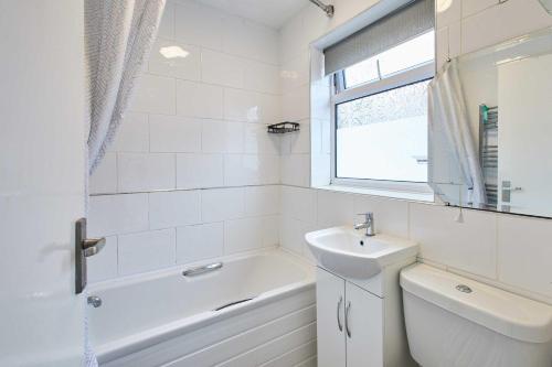 a white bathroom with a sink and a bath tub at Host & Stay - Shaftsbury in Burton Joyce