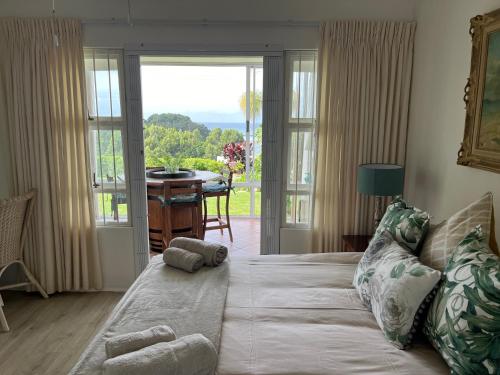 a bedroom with a bed with a view of a table at The Estuary Country Estate, Villa "Once Upon A Tide" in Port Edward