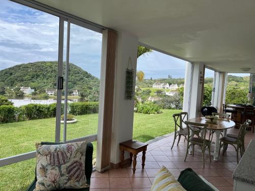 a screened in porch with a table and chairs at The Estuary Country Estate, Villa "Once Upon A Tide" in Port Edward