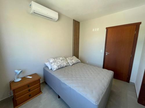 a small bedroom with a bed and a air conditioner at Residencial Alianza - Departamento 301 de 2 habitaciones in Bombinhas