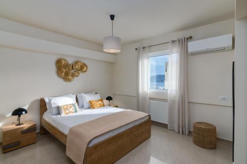 a bedroom with a large bed and a window at Oikies Luxury Apartments with private free parking area in Agios Nikolaos