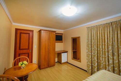 a living room with a table and a dining room at Hotel Cabanas Alto Da Serra in Canela