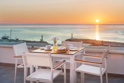 a table and chairs with a view of the ocean at Hotel Cala Bona in Cala Bona