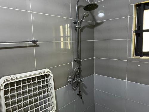 La salle de bains est pourvue d'une douche et d'un ventilateur. dans l'établissement Villa Meublée Cité Arconville 10min d'EREVAN CALAVI, à Abomey-Calavi