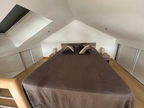 a bedroom with a large bed in a attic at Le Relais des Chevaliers "Gîte" in Cordes-sur-Ciel