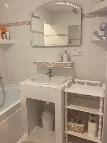 a white bathroom with a sink and a mirror at Útulný apartmán blízko centra in Michalovce