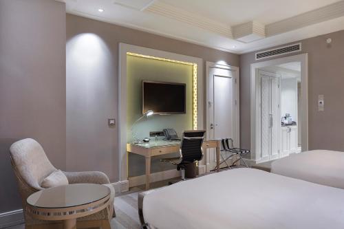 a bedroom with a bed and a desk with a computer at Hilton Bursa Convention Center & Spa in Bursa