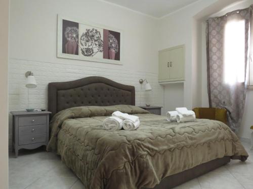 een slaapkamer met een groot bed en handdoeken bij Diamantea in Monopoli