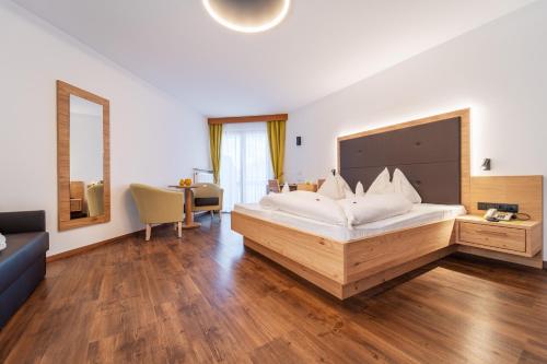 a bedroom with a large bed and a desk at Hotel Meinhardt in Schenna