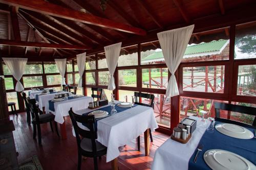 a restaurant with blue tables and chairs and windows at Tias Shelale Otel in Sile
