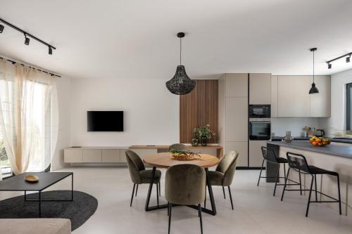 een keuken en een woonkamer met een tafel en stoelen bij Villa Medellin in Pridraga