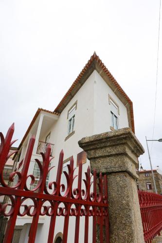 a white house behind a red fence at Gouveia Vintage House in Gouveia