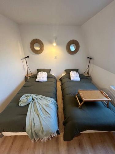 une chambre avec deux lits et une table dans l'établissement Chez Balthazar, à Elnes