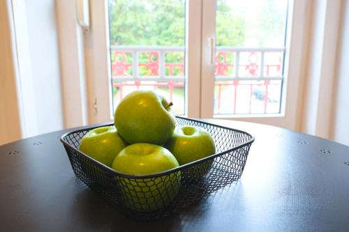a basket of green apples sitting on a table at Gouveia Vintage House in Gouveia