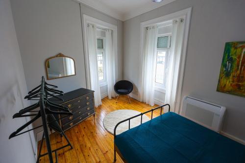 a bedroom with a blue bed and a mirror at Gouveia Vintage House in Gouveia