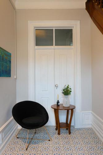 a black chair and a table in front of a door at Gouveia Vintage House in Gouveia