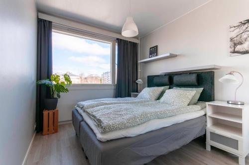sypialnia z łóżkiem z zielonym zagłówkiem i oknem w obiekcie Kaksio lähellä Turun jokirantaa w mieście Turku