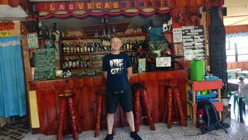 Ein Mann steht vor einer Bar. in der Unterkunft Las vegas lodge and restaurant in Banaue