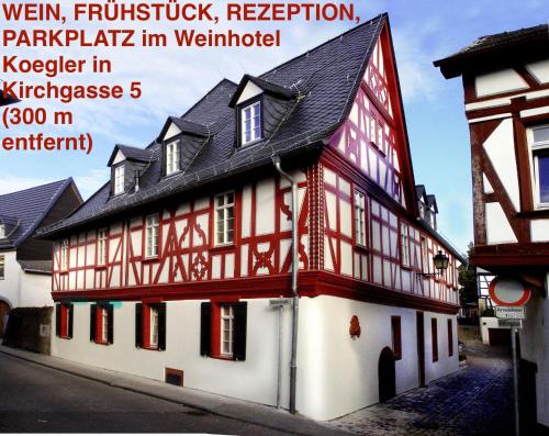 a red and white building with a black roof at Weinhotel Eltvinum in Eltville