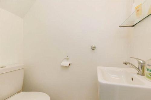 a white bathroom with a toilet and a sink at Affordable and comfort apartment in Ibadan