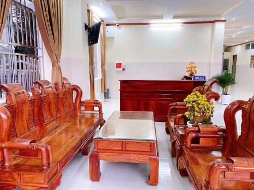 a waiting room with wooden benches and a piano at Tường Vi Motel in Hà Tiên