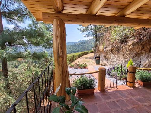 a wooden porch with a view of a mountain at Finca Chuchiyá cabañas Tecpan in Tecpán Guatemala