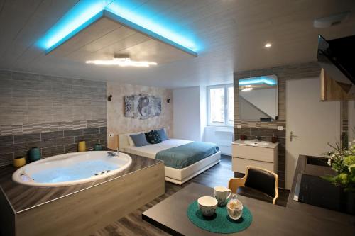 a large bathroom with a tub and a bed at Bulles Emotions in Arbois