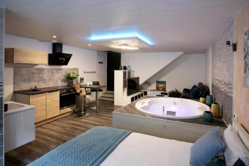 a large bathroom with a tub and a kitchen at Bulles Emotions in Arbois