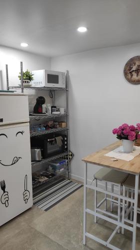 a kitchen with a refrigerator and a table with flowers at Casa Mejías, excelente localización, cerca de los principales puntos turísticos de Antequera in Antequera
