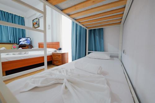 a bedroom with a white bed with a bow on it at Vila Limos in Ksamil
