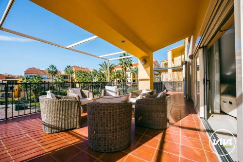 einen Balkon mit Korbstühlen und Stadtblick in der Unterkunft ViVi Homes - Casa Duque Pool, Terrace & Golf in Alhaurín de la Torre