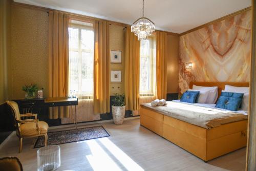 a bedroom with a large bed and a chandelier at Apartament Bursztynowa Komnata przy Zamkowej 1 w Wałbrzychu in Wałbrzych